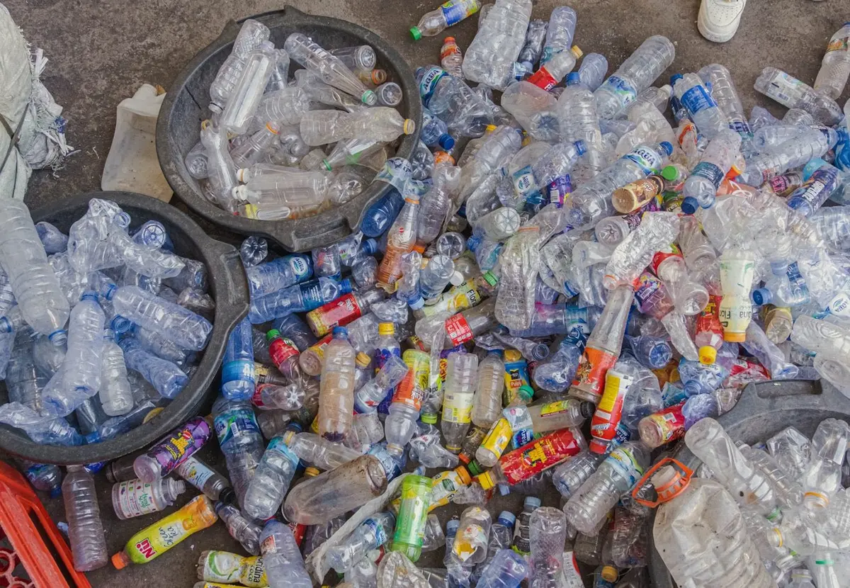 Sorted plastic bottles heaped in and around collection tubs
